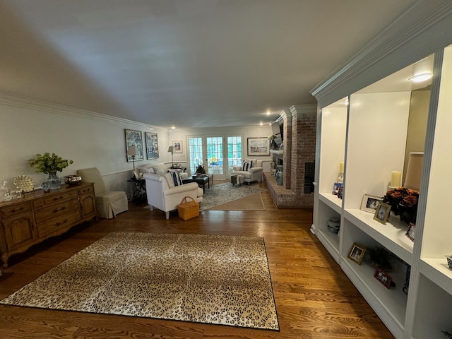 interior space featuring brick wall, crown molding, hardwood / wood-style floors, and a brick fireplace