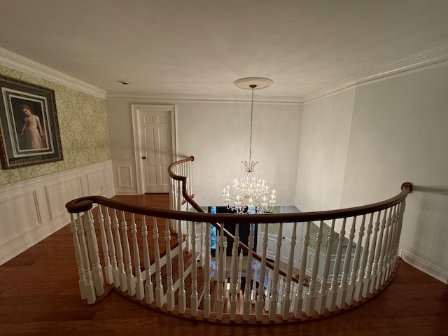 stairs with hardwood / wood-style floors, a notable chandelier, and ornamental molding