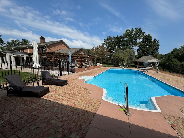 view of swimming pool with a patio area and a water slide