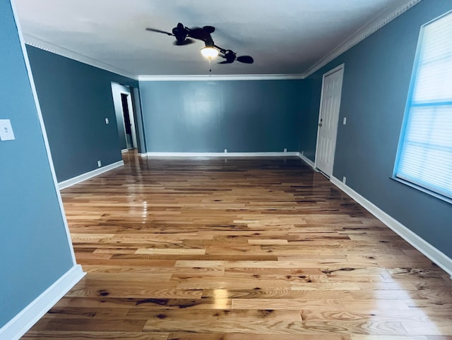 spare room featuring crown molding, a healthy amount of sunlight, hardwood / wood-style floors, and ceiling fan