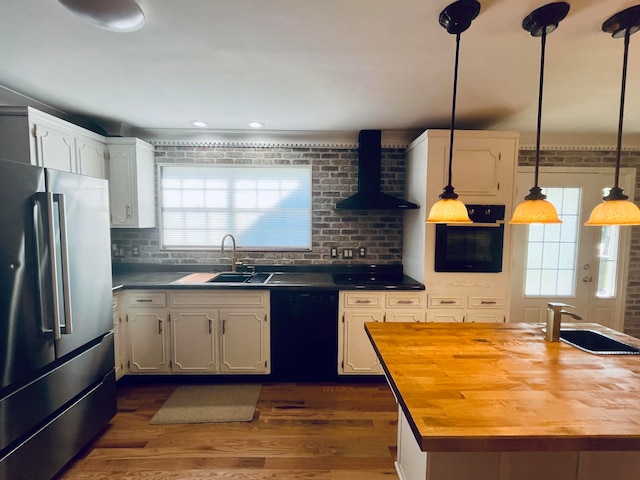 kitchen with sink, wall chimney range hood, black appliances, wooden counters, and dark wood-type flooring