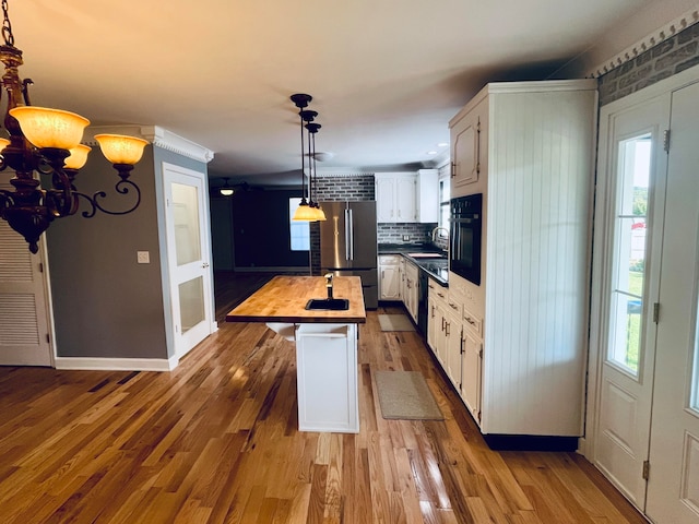 kitchen with dark hardwood / wood-style floors, stainless steel fridge, a center island, wooden counters, and white cabinets