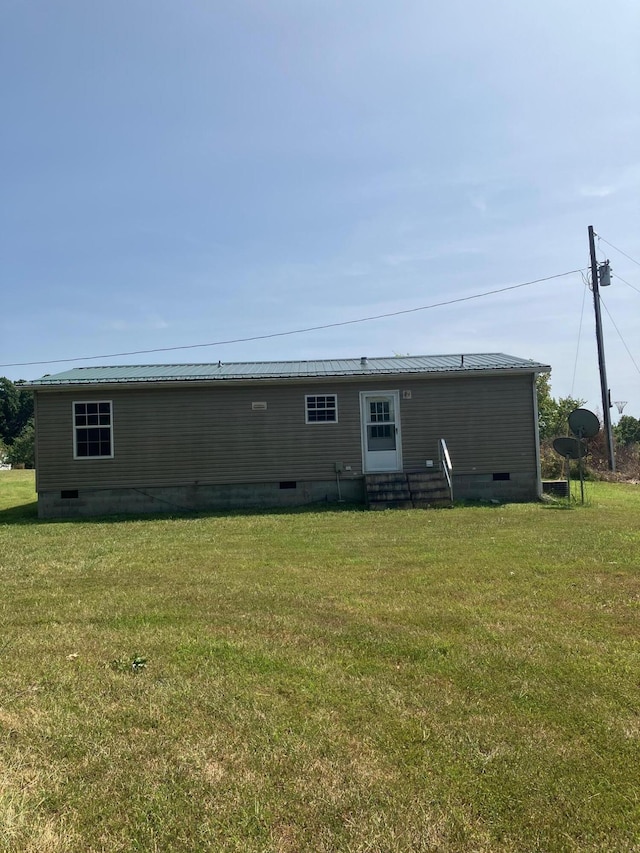 rear view of house featuring a yard