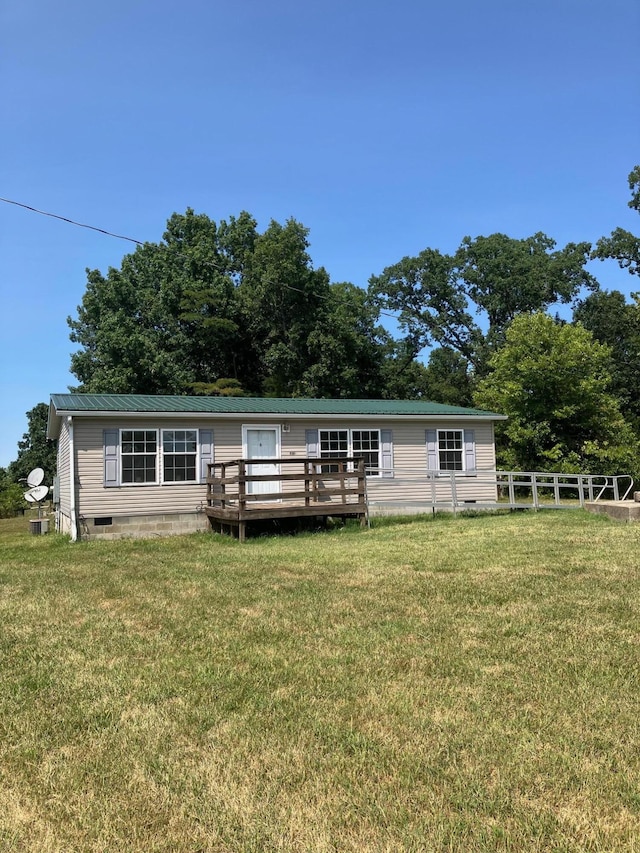 rear view of house featuring a wooden deck and a lawn