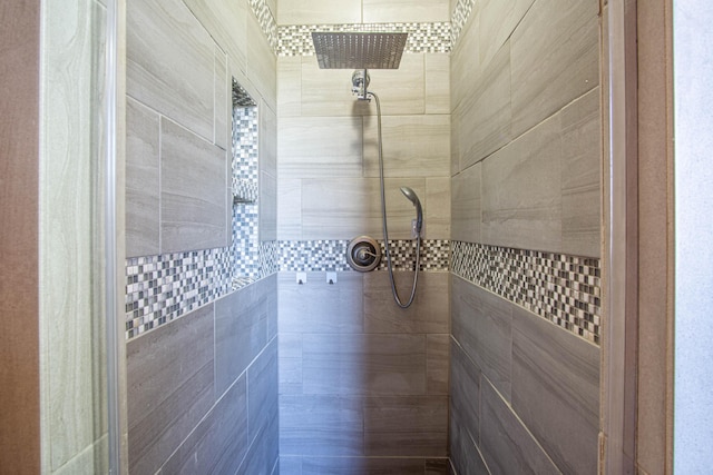 bathroom with tiled shower and tile walls