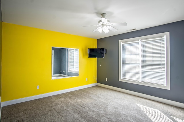 carpeted spare room with ceiling fan