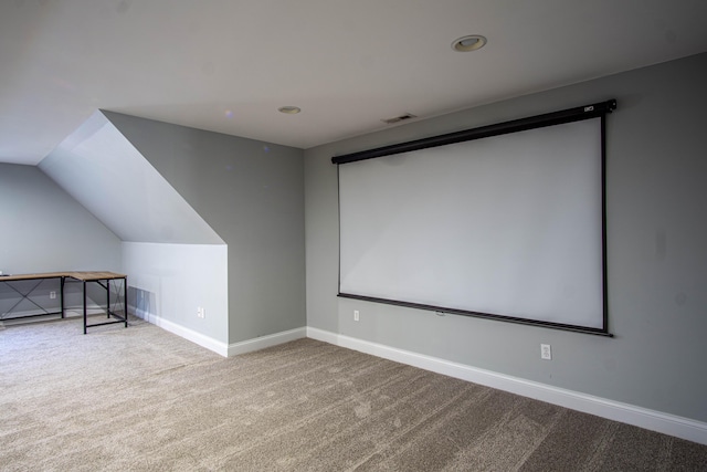 cinema room with carpet and lofted ceiling