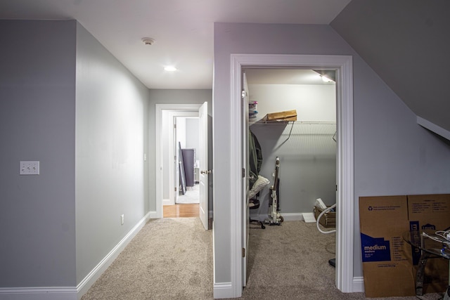 hall featuring light carpet and vaulted ceiling