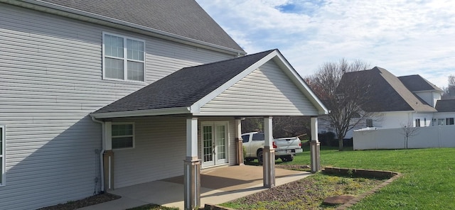 view of side of property featuring a lawn, a patio area, and french doors