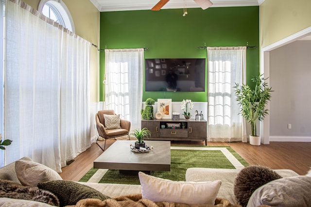 living room with light wood-type flooring, ceiling fan, and crown molding