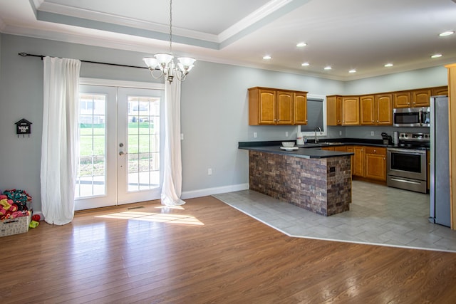 kitchen with french doors, appliances with stainless steel finishes, decorative light fixtures, light hardwood / wood-style floors, and kitchen peninsula