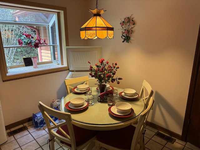 tiled dining space featuring baseboards and visible vents