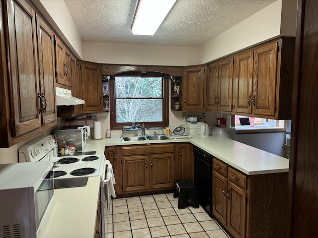 kitchen featuring light countertops, a sink, a textured ceiling, white appliances, and under cabinet range hood