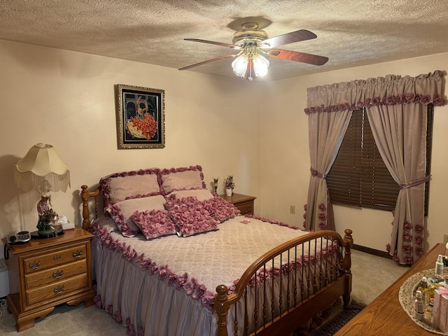 bedroom with a ceiling fan, light colored carpet, and a textured ceiling