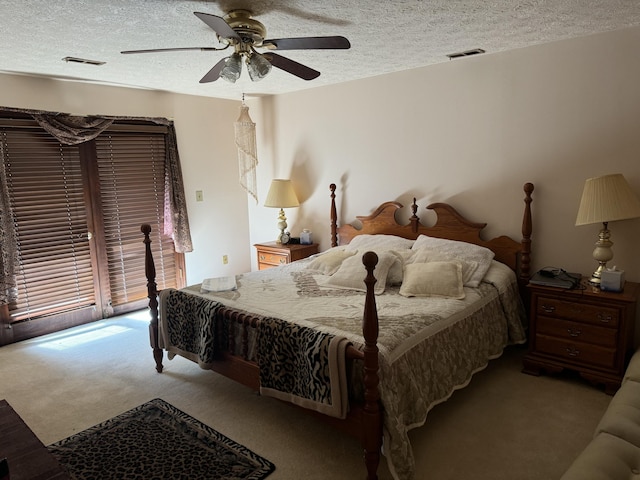 bedroom with carpet floors, visible vents, a textured ceiling, and a ceiling fan