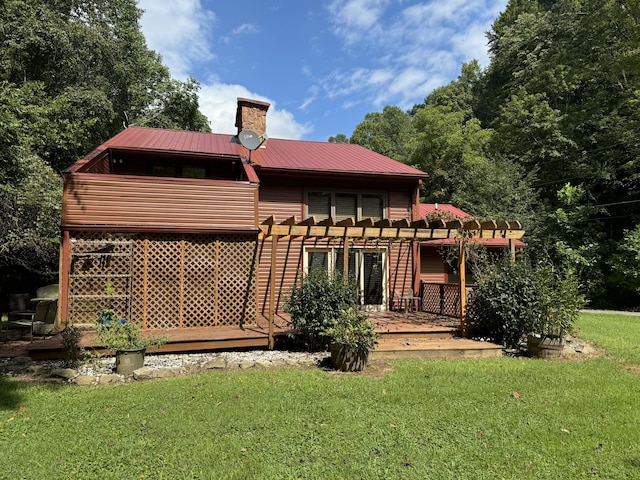 back of property featuring a yard, a chimney, metal roof, a pergola, and a wooden deck