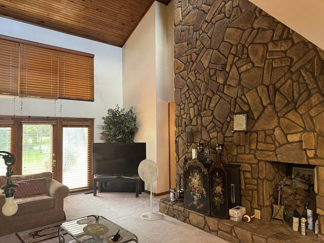 living area with carpet floors, a stone fireplace, high vaulted ceiling, and wood ceiling