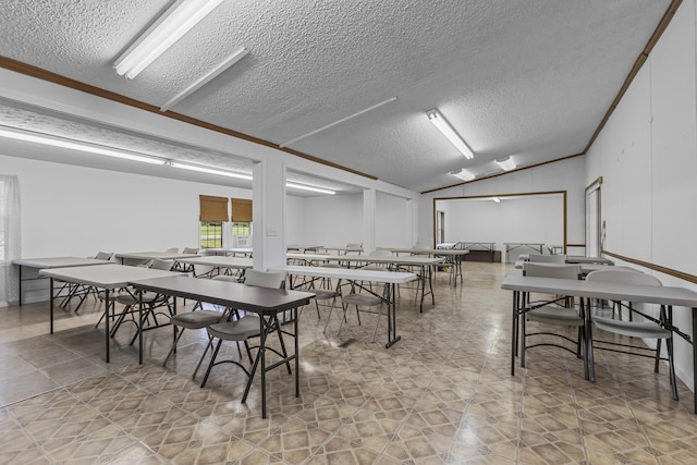 rec room with lofted ceiling, ornamental molding, and a textured ceiling