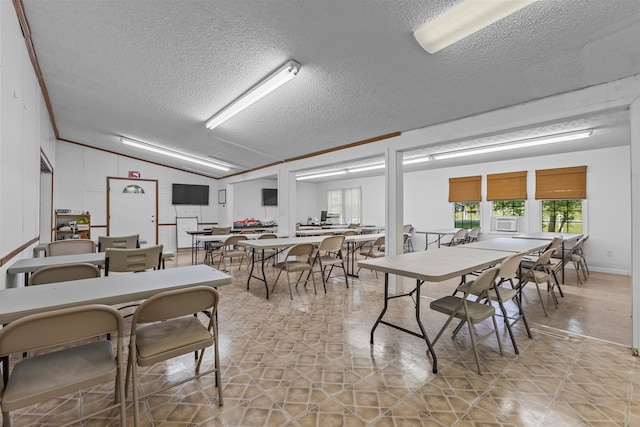 tiled dining room with ornamental molding, vaulted ceiling, and a textured ceiling