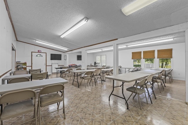 dining room featuring vaulted ceiling and a textured ceiling