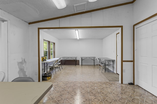 interior space with a textured ceiling and tile patterned floors