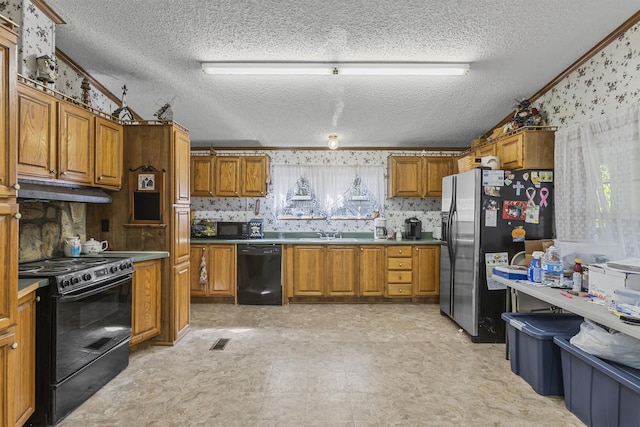 kitchen with visible vents, brown cabinetry, a sink, under cabinet range hood, and black appliances