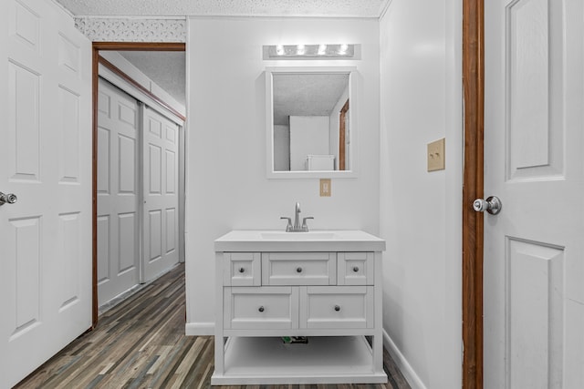 bathroom with a textured ceiling, vanity, and hardwood / wood-style floors