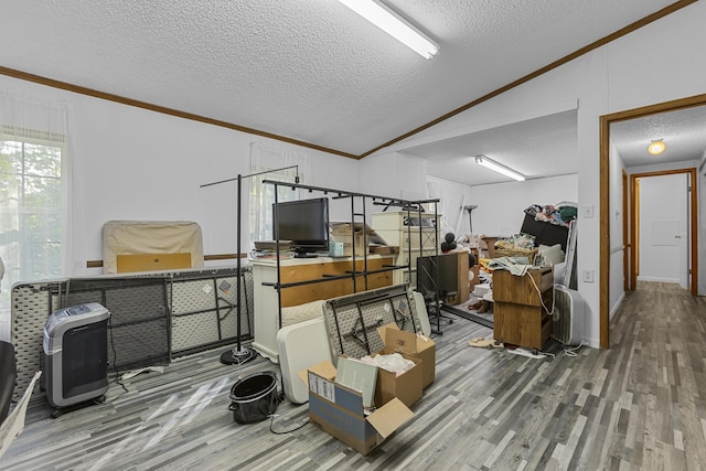 interior space featuring a textured ceiling, wood finished floors, lofted ceiling, and crown molding