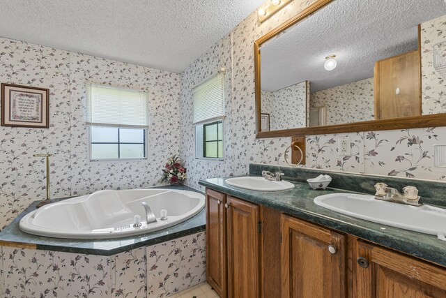 bathroom with vanity, a textured ceiling, tile patterned floors, and tiled bath