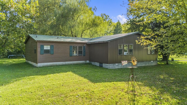 exterior space with crawl space, metal roof, and a yard