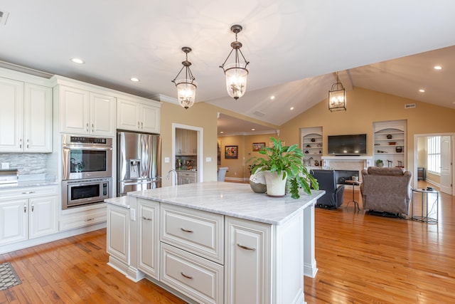 kitchen with white cabinets, a center island, light hardwood / wood-style flooring, decorative light fixtures, and stainless steel appliances