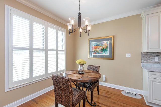 dining room featuring ornamental molding, an inviting chandelier, and light hardwood / wood-style floors