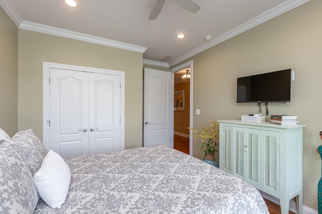 bedroom featuring ornamental molding, a closet, hardwood / wood-style floors, and ceiling fan with notable chandelier