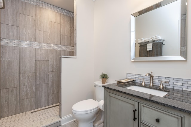 bathroom with vanity, toilet, backsplash, and a shower