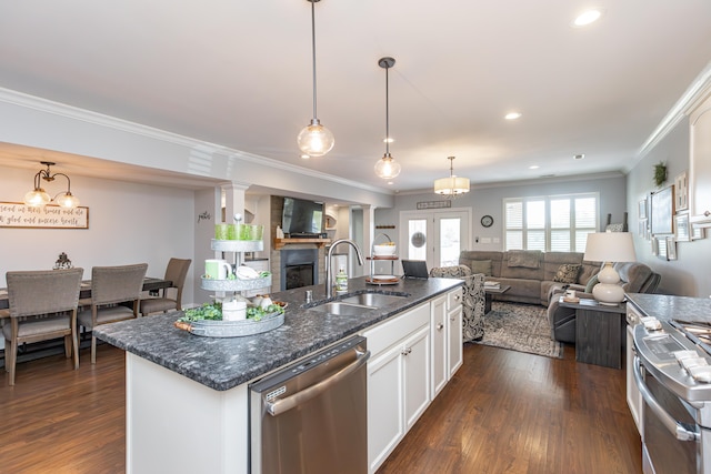 kitchen with a kitchen island with sink, white cabinetry, sink, dark wood-type flooring, and appliances with stainless steel finishes