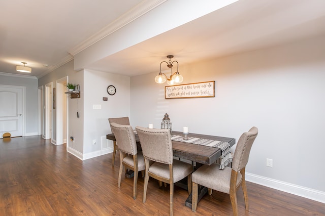 dining space featuring dark wood-type flooring, crown molding, and a notable chandelier