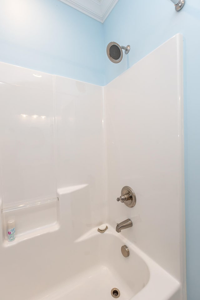 bathroom with ornamental molding and washtub / shower combination