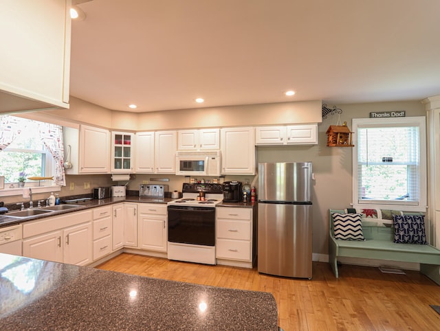 kitchen with sink, white cabinetry, light hardwood / wood-style floors, and white appliances