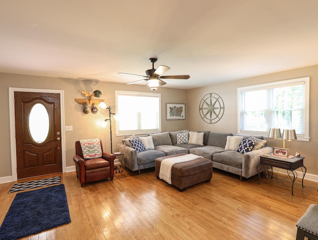 living room featuring ceiling fan, light wood-type flooring, and plenty of natural light