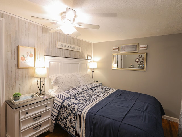 bedroom featuring a textured ceiling, ceiling fan, and dark hardwood / wood-style floors