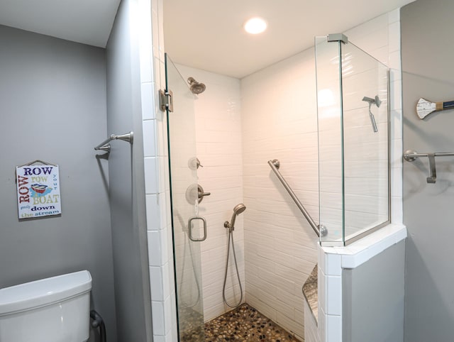 bathroom featuring an enclosed shower and toilet