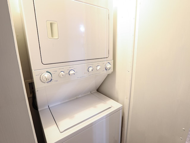 clothes washing area featuring stacked washer and clothes dryer