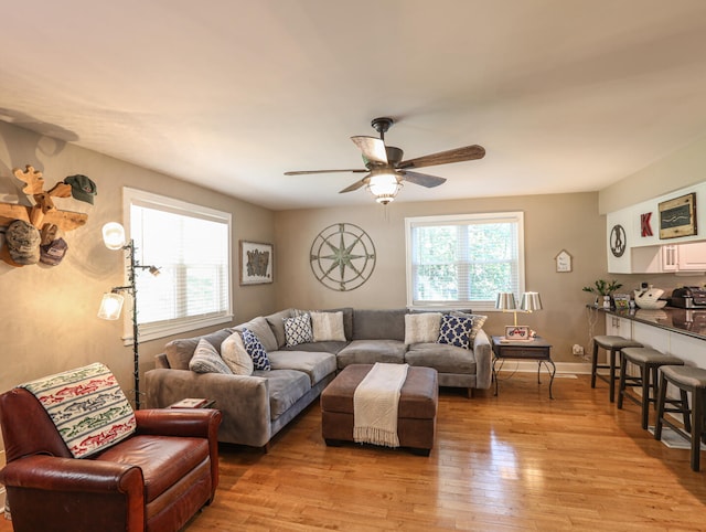 living room with ceiling fan and light hardwood / wood-style flooring