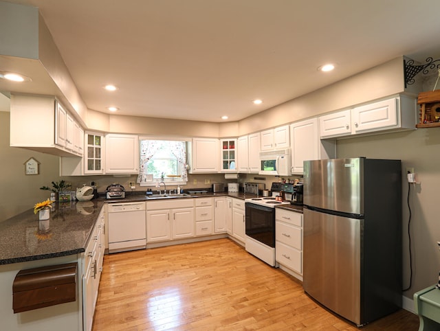 kitchen with light hardwood / wood-style floors, sink, white cabinets, kitchen peninsula, and white appliances