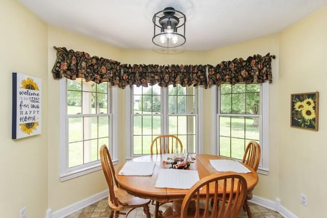 dining space featuring plenty of natural light and baseboards