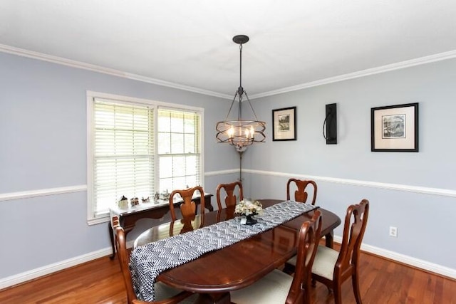 dining area featuring crown molding, baseboards, and wood finished floors