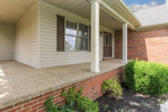 view of property exterior featuring a porch and brick siding