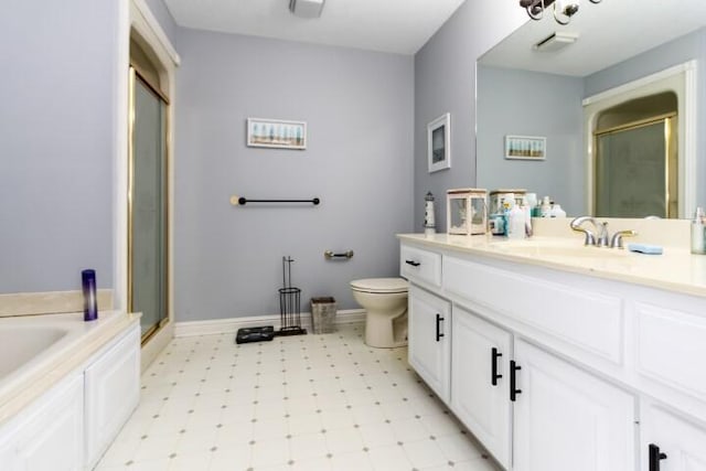 bathroom with a stall shower, vanity, baseboards, and tile patterned floors