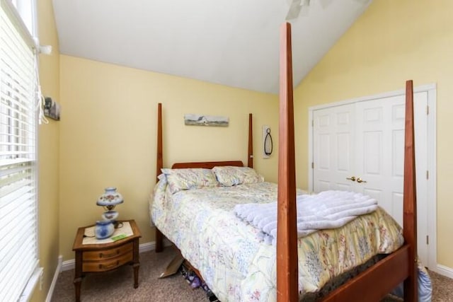 carpeted bedroom featuring lofted ceiling and baseboards