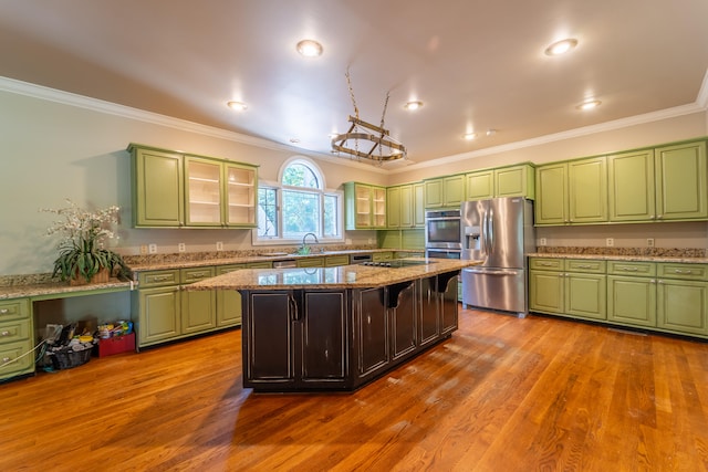 kitchen featuring light stone countertops, stainless steel appliances, light wood-type flooring, crown molding, and a center island